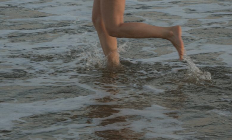 Mulher correndo no oceano.